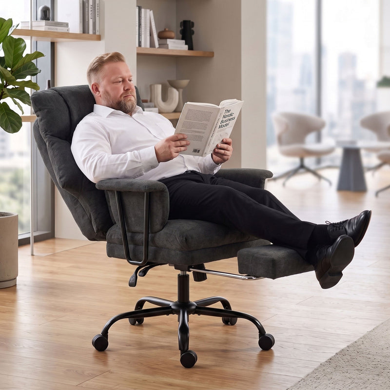 Man reclining in the Homcom office chair with footrest extended, reading a book