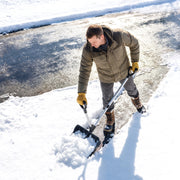 Overhead view of a man clearing icy pavement with the snow shovel