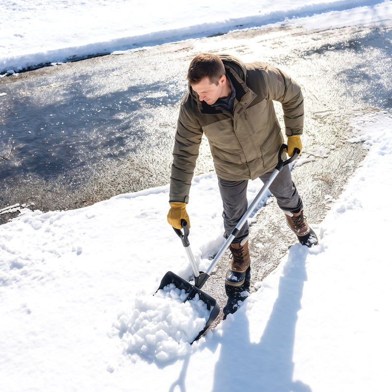 Overhead view of a man clearing icy pavement with the snow shovel