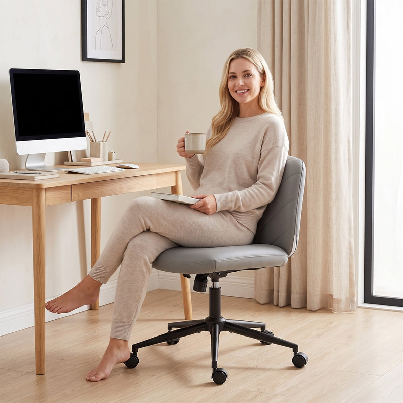 Woman sitting at a desk with a monitor in the grey chair
