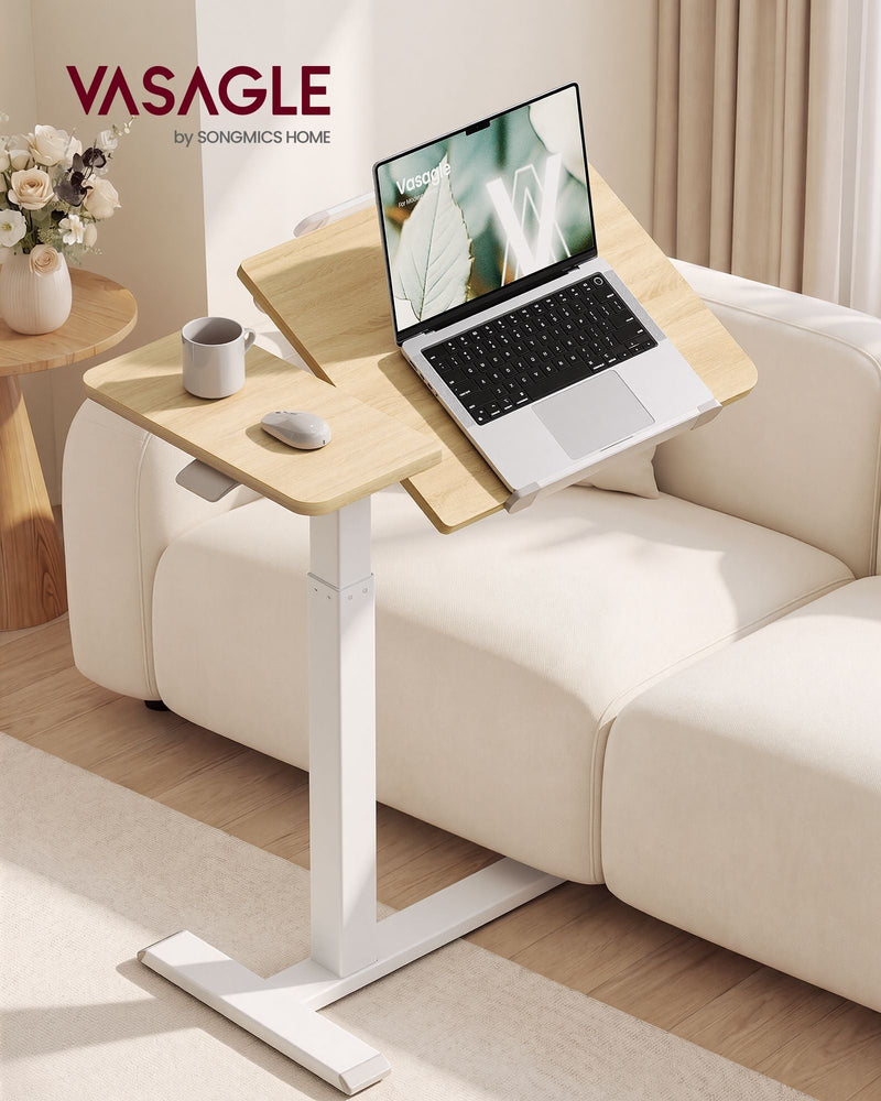 Golden Oak overbed laptop table beside a cream sofa with a laptop on the tilted panel
