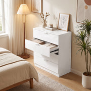 White high gloss chest of drawers with a drawer open beside a bed