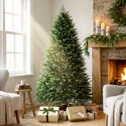 6ft artificial Christmas tree beside a stone fireplace with candles and wrapped gifts at its base