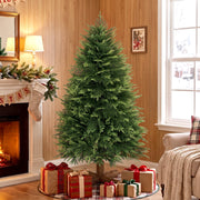 5ft artificial Christmas tree in a wood-panelled room beside a fireplace with wrapped gifts at its base
