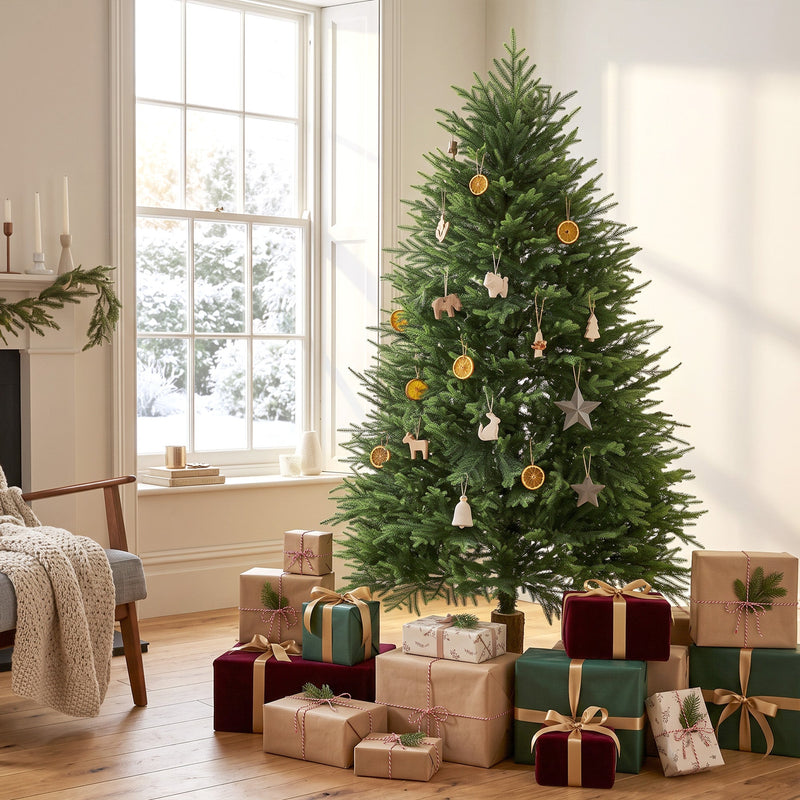 Decorated 5ft Christmas tree with dried orange slice ornaments in a bright living room with gifts