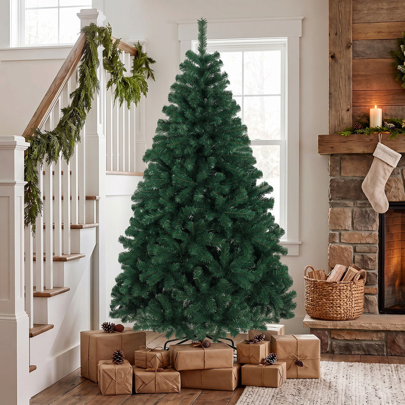 Green Christmas tree in a hallway by a staircase with garland and wrapped gifts around the stand
