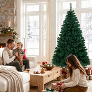 Family relaxing on a sofa in a bright living room with the tree behind and a girl wrapping gifts