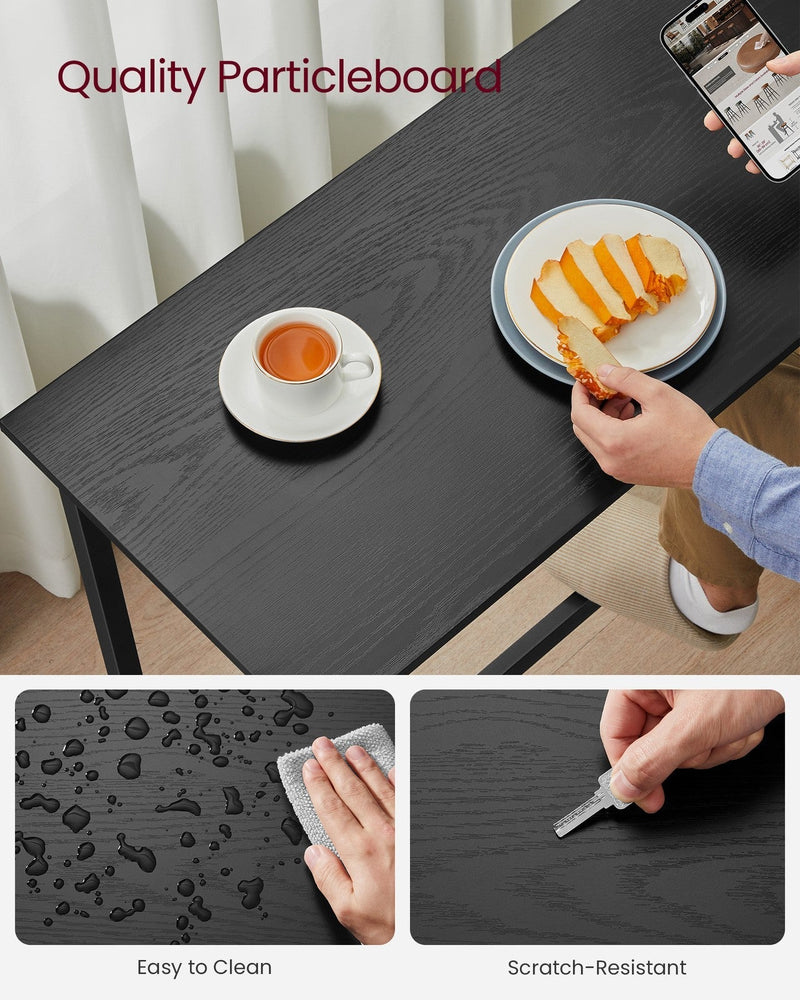 Close-up of the black particleboard tabletop showing its scratch-resistant, wipeable finish