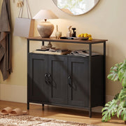 Black sideboard in a hallway with a lamp and fruit bowl on top