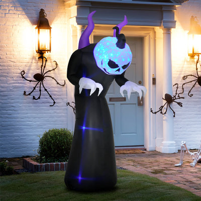 Inflatable ghost standing on a front lawn beside a lit porch at dusk