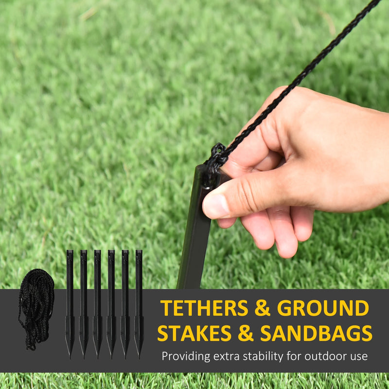 Hand pushing a ground stake into grass beside spare stakes and tethers