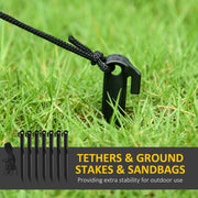Ground stakes and tether ropes pushed into grass to anchor the decoration