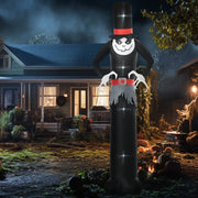 Tall ghost lit up on a lawn at night beside a house and pumpkins