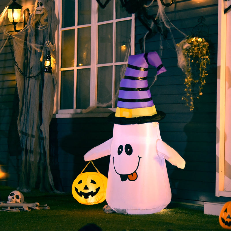 Witch hat ghost inflatable lit up beside a window draped in Halloween cobwebs