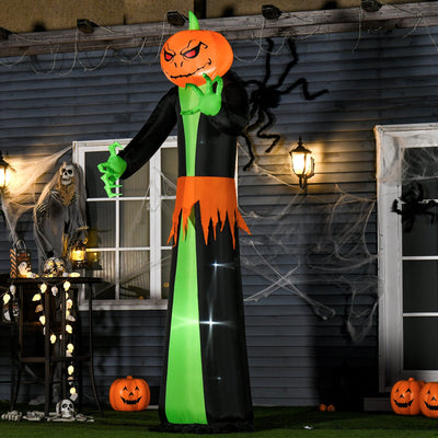 Pumpkin reaper lit up at night against a house wall hung with cobwebs