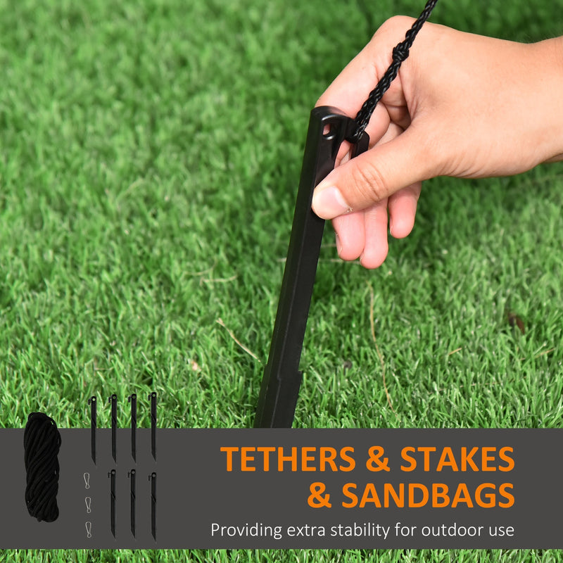 Hand pushing a black ground stake into grass beside the inflatable