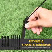 Hand pushing one of the 5 ground stakes into a lawn