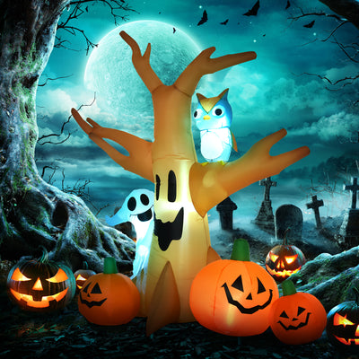 The Halloween tree lit up at night against a moonlit graveyard scene