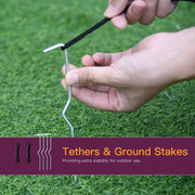 Hands pushing a metal ground stake into grass to anchor the Halloween display