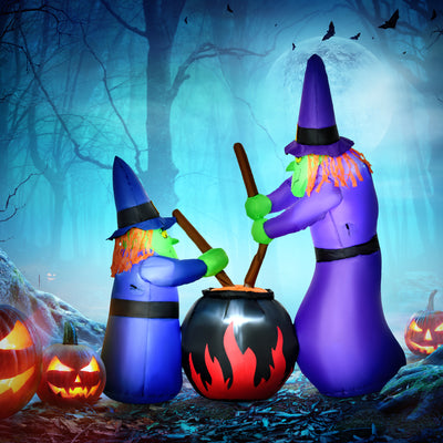 The lit witches and cauldron display set in a misty graveyard at night