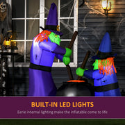 The witches display glowing beside a cobwebbed house porch after dark