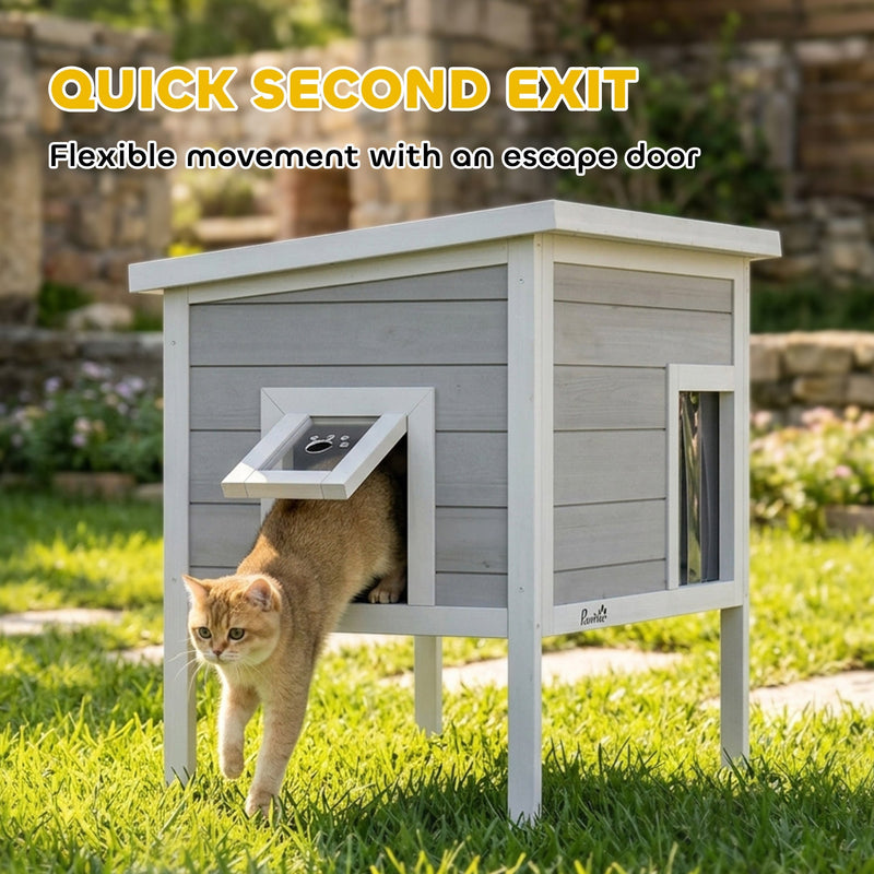 Cat stepping out through the side escape door of the PawHut cat house on grass