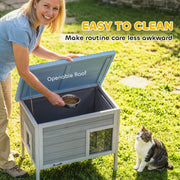 Owner lifting the openable roof to reach inside the cat house for feeding and cleaning