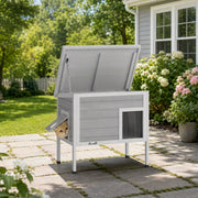 PawHut cat house with roof lifted open and a cat peeking out of the escape door in a garden