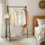 Black iron A-frame clothes rack with hanging rail and mesh bottom shelf styled with clothes and accessories