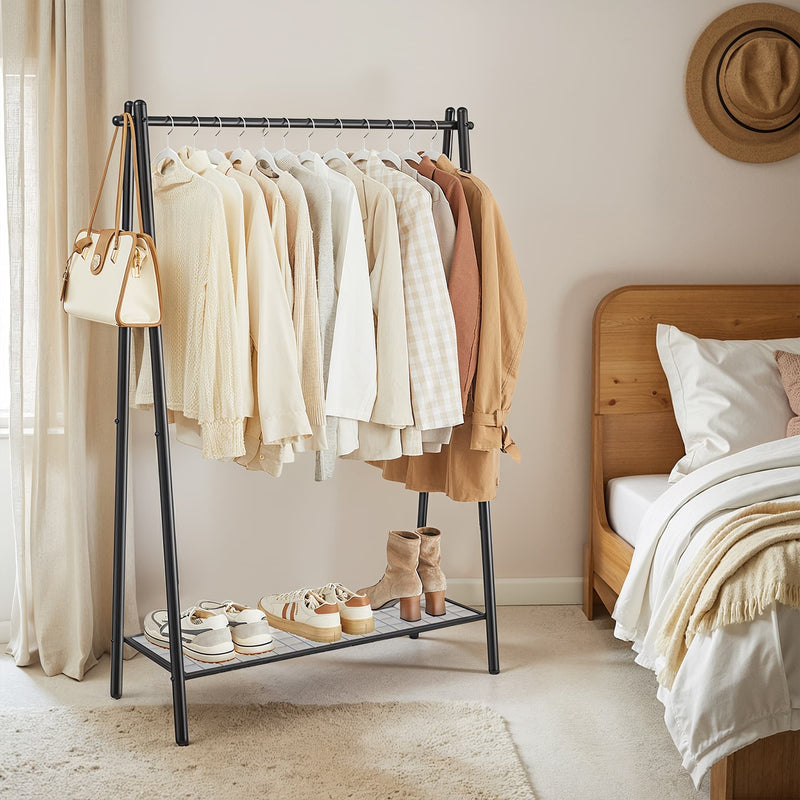 Black iron A-frame clothes rack with hanging rail and mesh bottom shelf styled with clothes and accessories