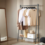 Clothes rack hanging rail holding shirts and dresses above shoes and a storage box on the bottom shelf