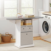 Ironing board cabinet with iron and folded towels beside a washing machine