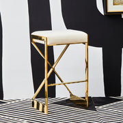 Ivory velvet bar stool with gold finish frame against a black and white graphic backdrop