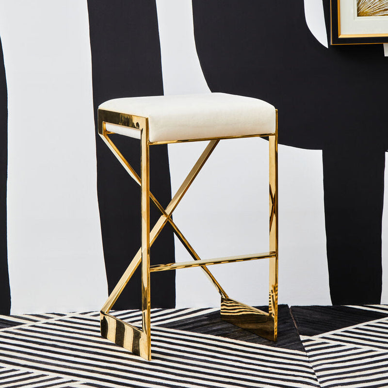 Ivory velvet bar stool with gold finish frame against a black and white graphic backdrop