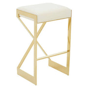 Three-quarter view of ivory velvet bar stool with gold cross-frame legs