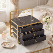 The jewellery box on a white bed with rings, a perfume bottle and a small dish