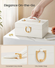 Close-up of the jewellery box's carry handle and gold-tone clasp being lifted by hand