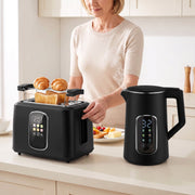 Woman using the toaster and kettle set in a kitchen