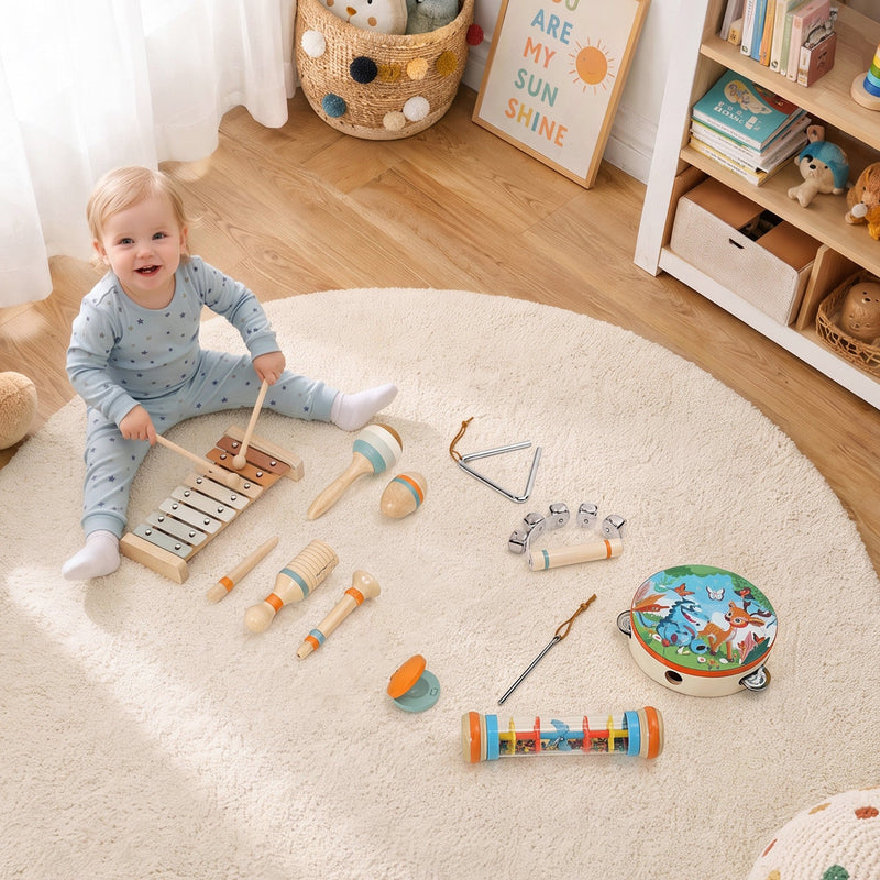 Baby playing the xylophone on a rug with the other instruments around