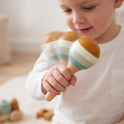 Toddler shaking a wooden maraca in close-up