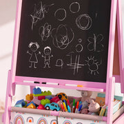 Close-up of chalk drawings on the pink easel chalkboard above bins full of toys