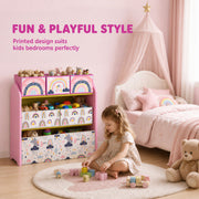 Pink toy storage rack beside a canopy bed with a girl playing on the rug