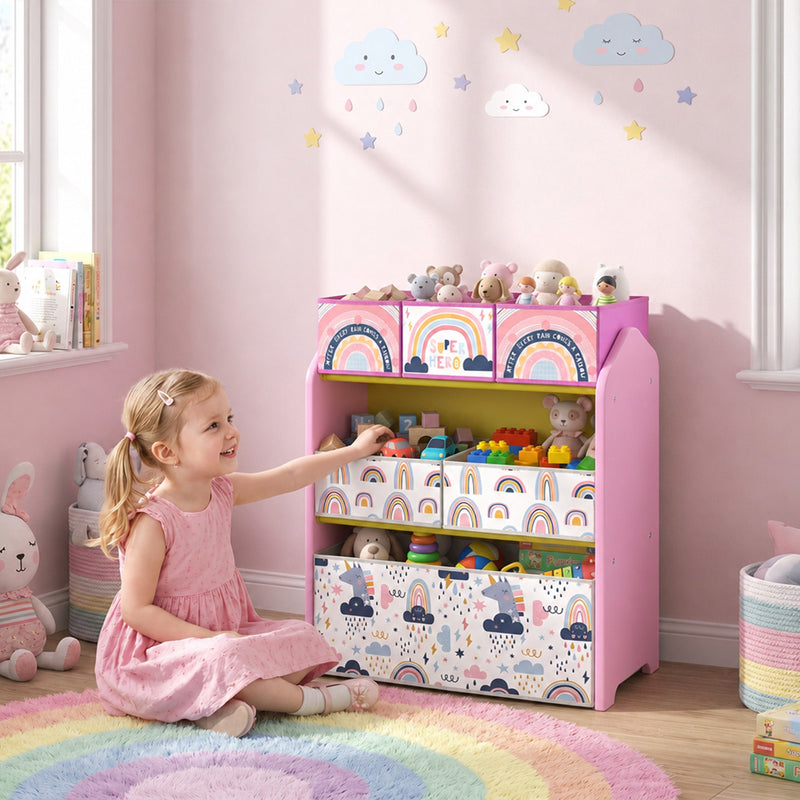Girl tidying toys onto the pink toy rack in a playroom beside a rainbow rug