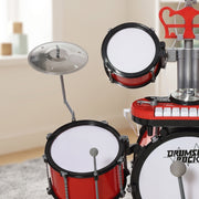 Child seated on the stool playing the red drum kit