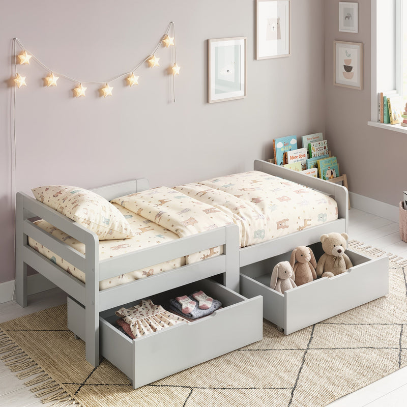 Grey kids bed with both drawers pulled out showing clothes and soft toys