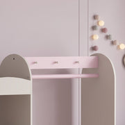 Close-up of the three bow shaped hooks above the pink hanging rod