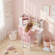 Girl drawing at the pink kids desk and chair set in a bedroom