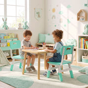 Two boys drawing at a wooden table on matching kids chairs in a playroom