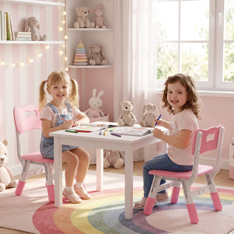 Two smiling girls drawing at a table, seated on a pair of kids chairs