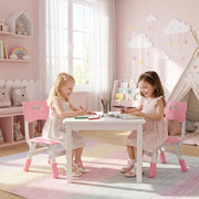 Two girls drawing at a table on kids chairs beneath cloud wall decorations
